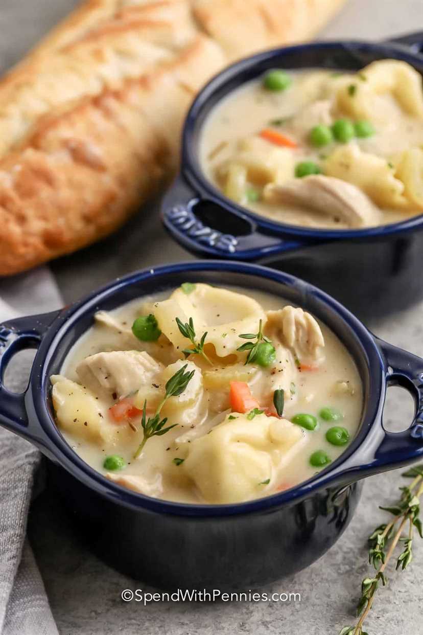 close up of Creamy Chicken Tortellini Soup in bowls with bread