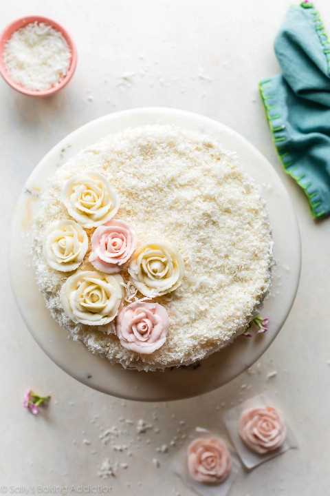 Tiro de arriba de la torta de coco con rosas de crema de mantequilla