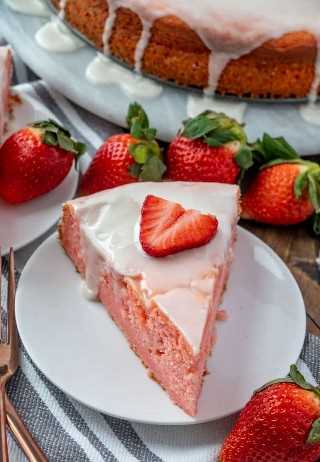 Foto aérea de rebanada de pastel en un plato blanco rodeado de fresas
