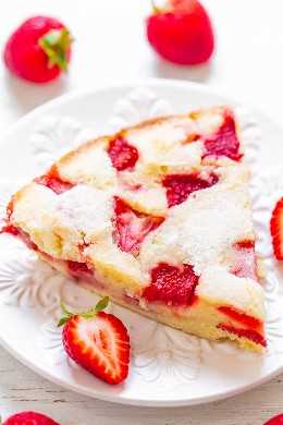 rebanada de pastel de fresa fresca sin corteza en un plato blanco con bayas frescas