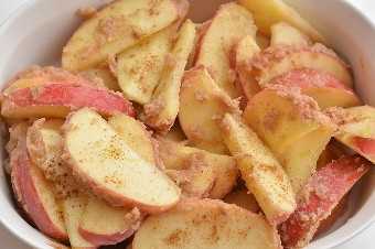 Rebanadas de manzana al horno: tazón de manzanas con mantequilla y mezcla de azúcar morena