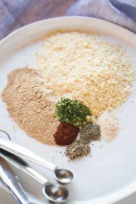 Un plato blanco con cucharadas de las diversas especias necesarias para hacer una mezcla casera de sopa de cebolla seca.
