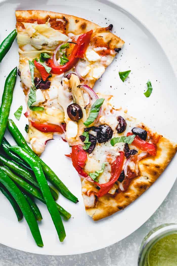 Rebanadas de pizza griega en un plato con judías verdes