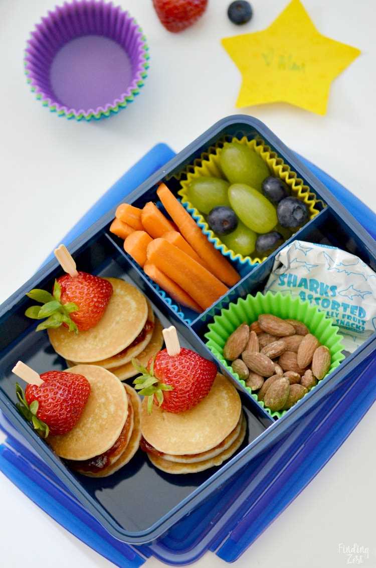 Mini Pancake Stacks in a School Lunchbox with fresh fruit, almonds and fruit snacks