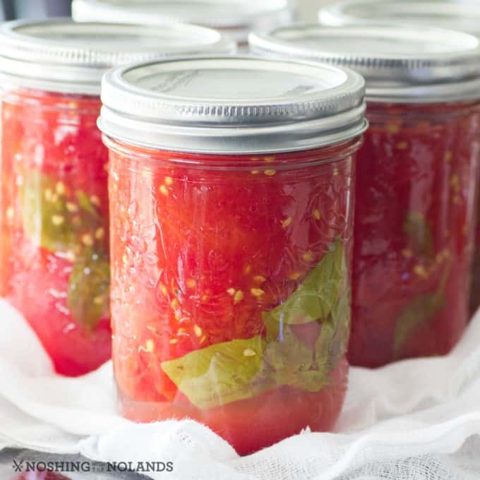Tomates enlatados caseros simples y fáciles en frascos sobre una encimera en una gasa