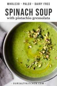 Sobre una mesa de mármol había un cuenco gris lleno de sopa verde de papa y espinacas, adornado con pistacho gremolata.