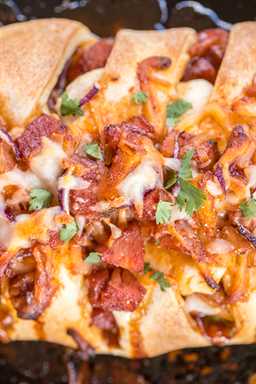 Hawaiian BBQ Pizza Braid - ¡listo en menos de 30 minutos! Jamón, piña, salsa BBQ, mozzarella, cilantro y cebolla roja horneados en masa de pizza refrigerada. ¡Un giro divertido a la noche de pizza! ¡A todos les ENCANTA este pan relleno fácil! # pizza #hawaiianbbqpizza #bbqpizza