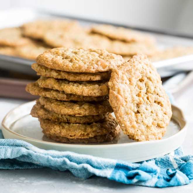 Oatmeal scotchies stacked on a white plate.