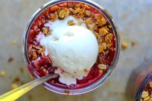 plum crisp in a glass with scoop of vanilla ice cream