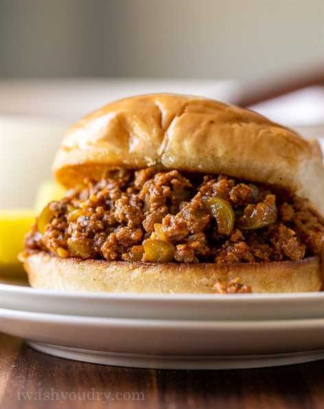 Piled high Sloppy Joe meat on toasted bun with dill pickle