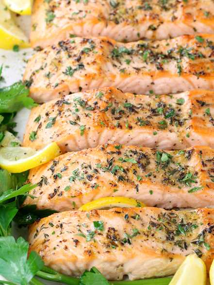 eye level close up partial platter of baked salmon filets with lemon pepper