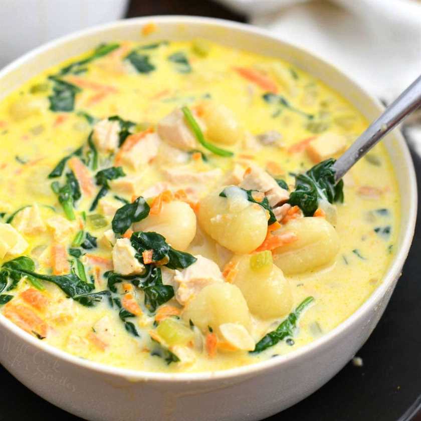 close up photo: creamy soup with spinach, chicken, and gnocchi