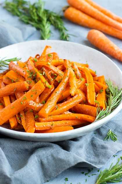 Roasted carrots in a white bowl with a gray napkin.