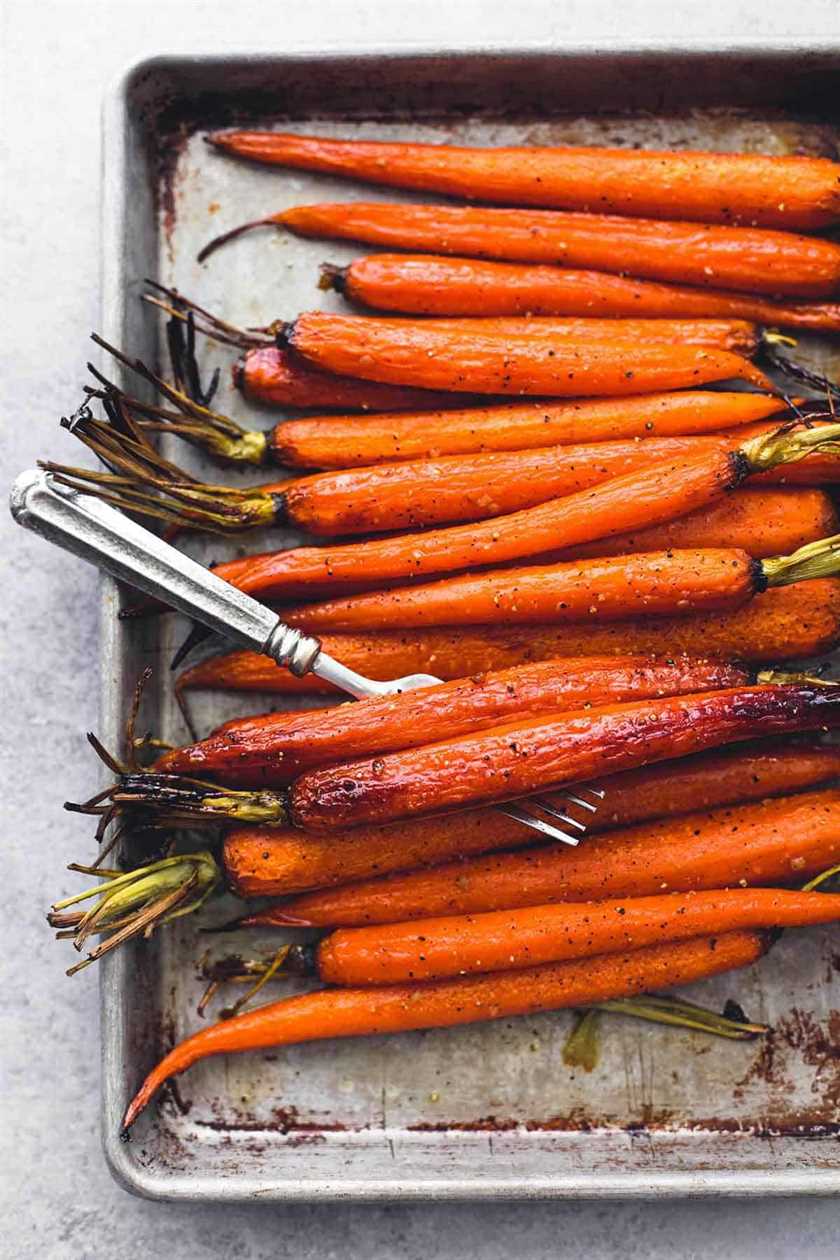 overhead view of roasted whole carrots on sheet pan with fork