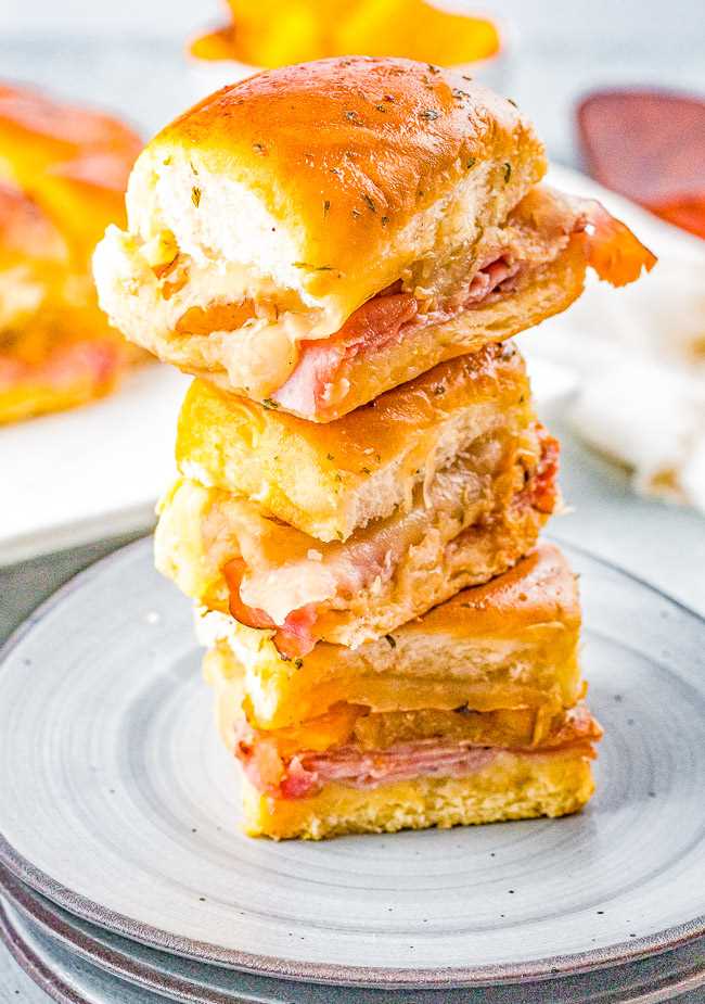Hawaiian Ham and Cheese Sliders - Grilled pineapple slices brushed with a soy and ginger marinade add a Hawaiian-inspired twist to these irresistible sandwiches! Juicy ham, melted Swiss cheese, and melted butter are impossible to resist! FAST, EASY, perfect as a game day or party appetizer, snack, or quick weeknight dinner!