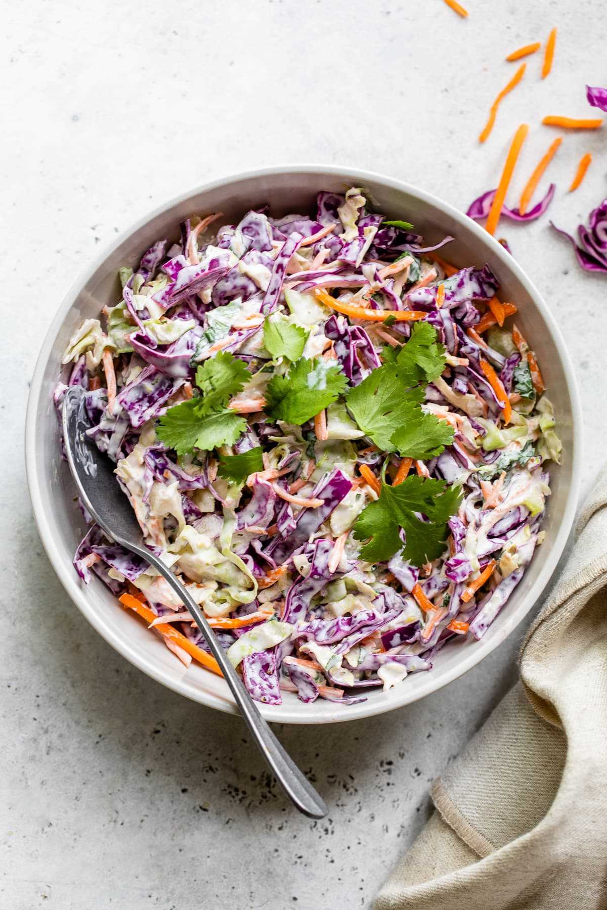 Fish taco slaw in a bowl topped with cilantro leaves.