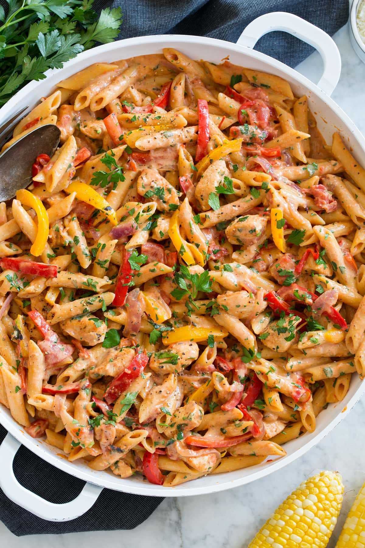 Photo: Creamy cajun chicken pasta shown in a large white pan from overhead.