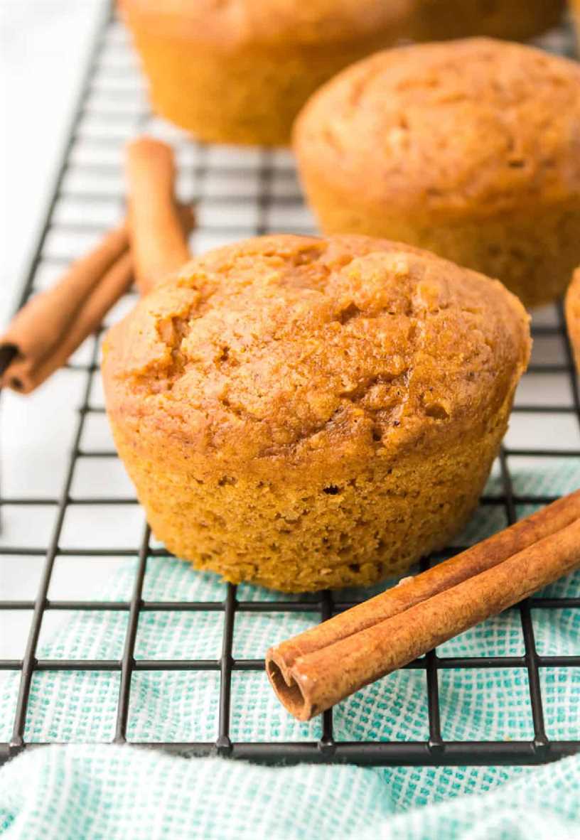 Ponga un muffin en una rejilla para enfriar con ramas de canela.