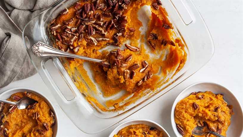 overhead view of a baking dish of healthy sweet potato casserole with some scooped out into bowls