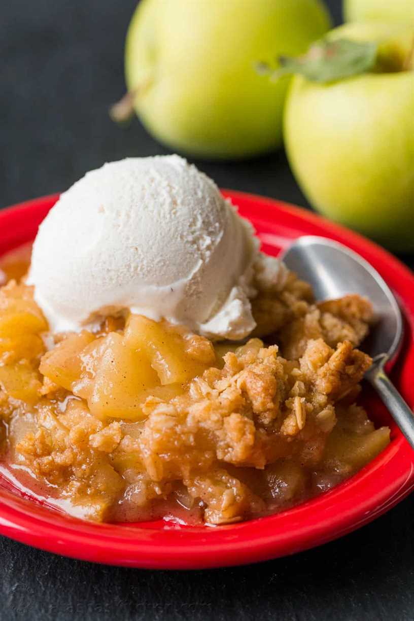 Plate of apple crisp served with vanilla ice cream and spoon