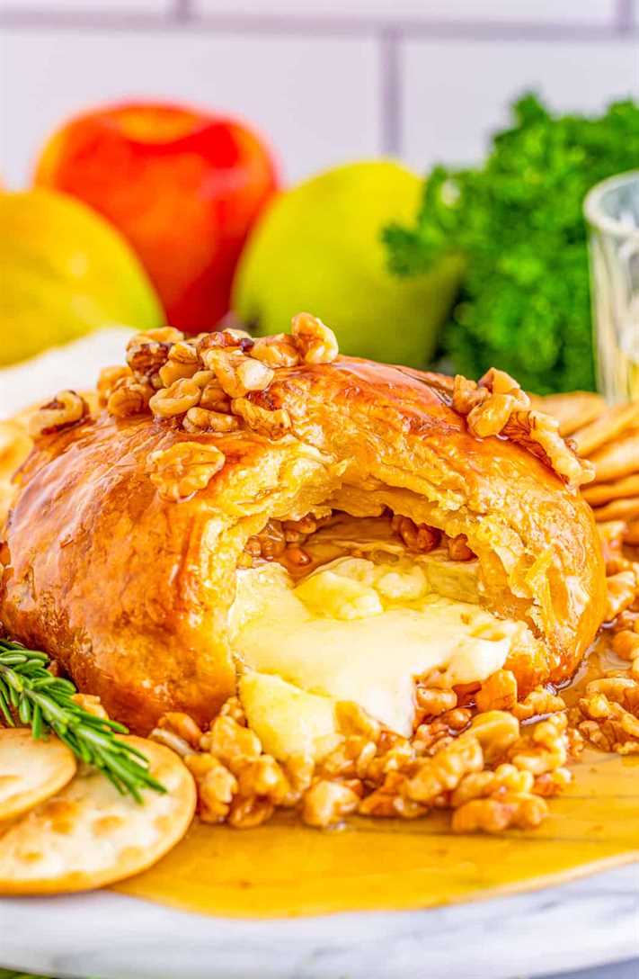 Honey Walnut Baked Brie Recipe with cheese oozing out of the center.