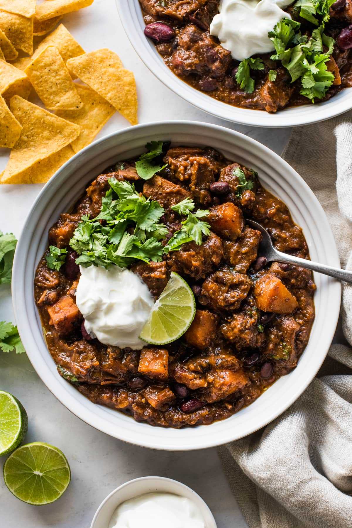 Pork chili in a bowl made from beans, sweet potatoes, pork shoulder, and chipotle spices.