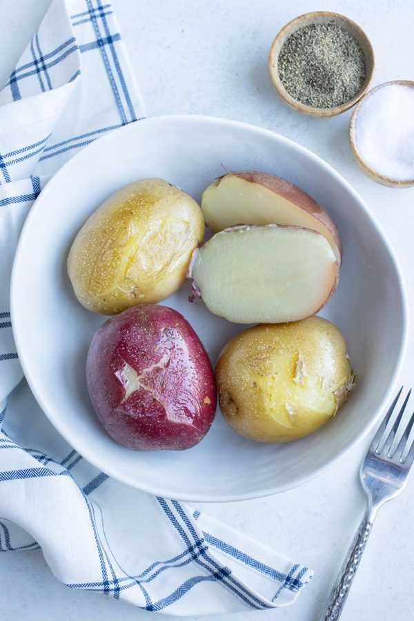 A bowl is used to hold red potatoes and golden potatoes that have been boiled.