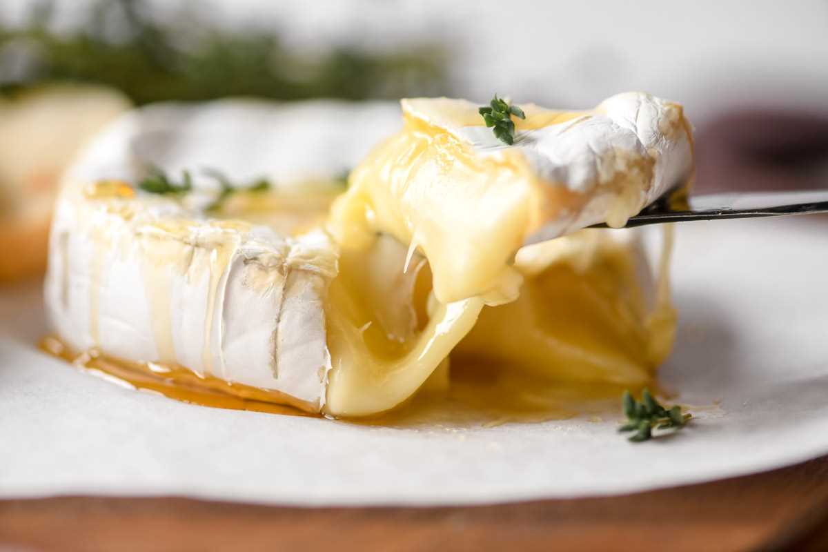 taking a wedge of gooey baked Brie