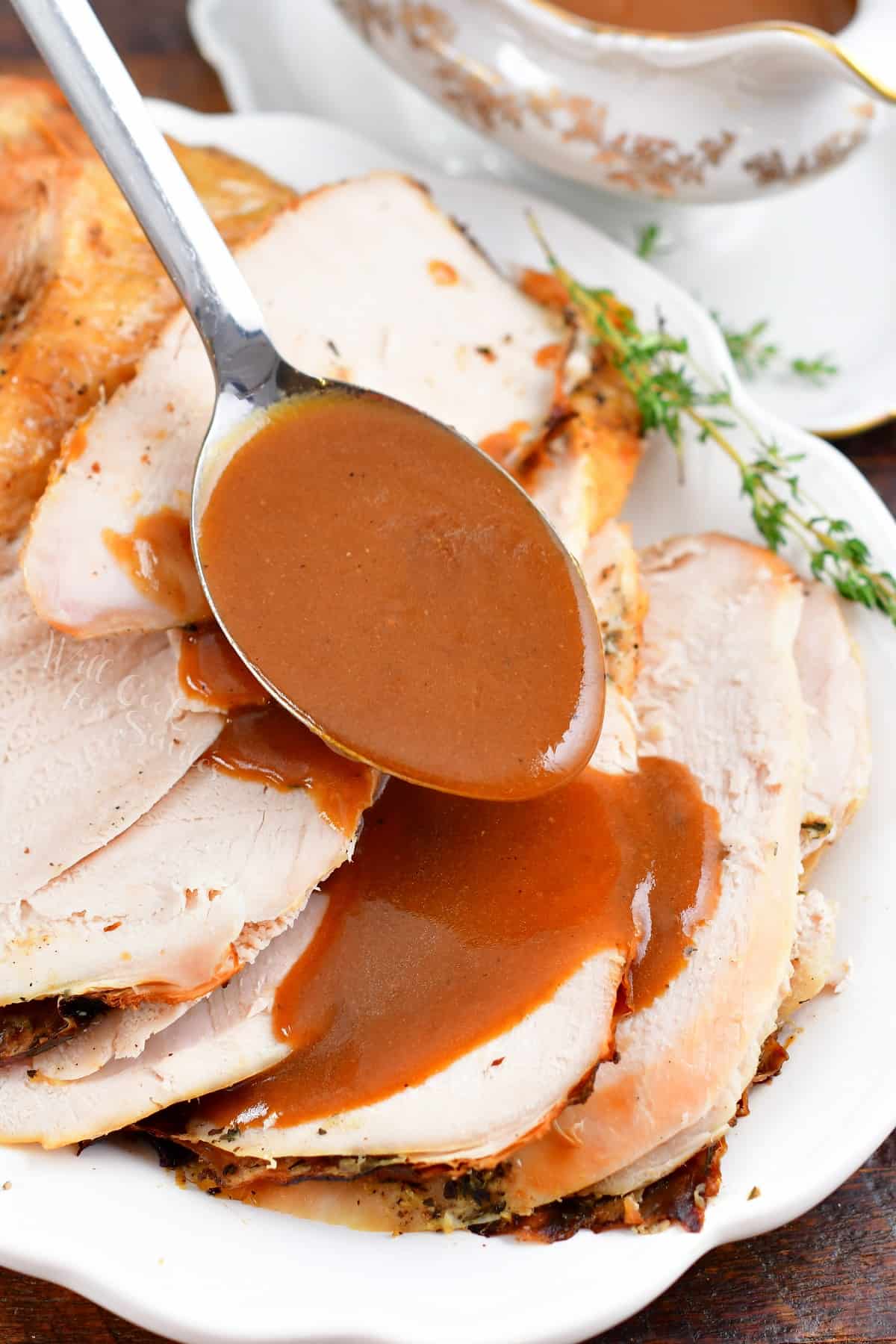 pouring gravy over sliced turkey breast