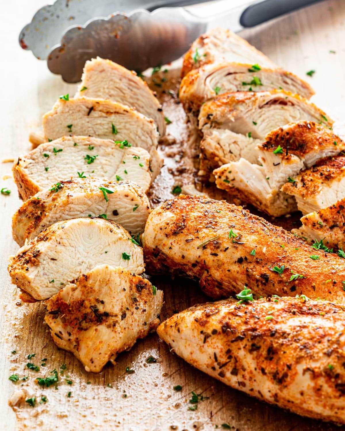 sliced up chicken breasts on a cutting board