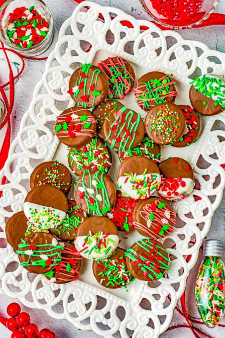 Chocolate Covered Christmas Oreos - Oreo cookies dipped in chocolate and loaded with sprinkles are an irresistible holiday treat! Fast, EASY, no-bake, can be made in advance! Perfect for cookie exchanges and hostess gifts. Get ready to break out the sprinkles and have fun making and then eating these family favorite Christmas cookies!