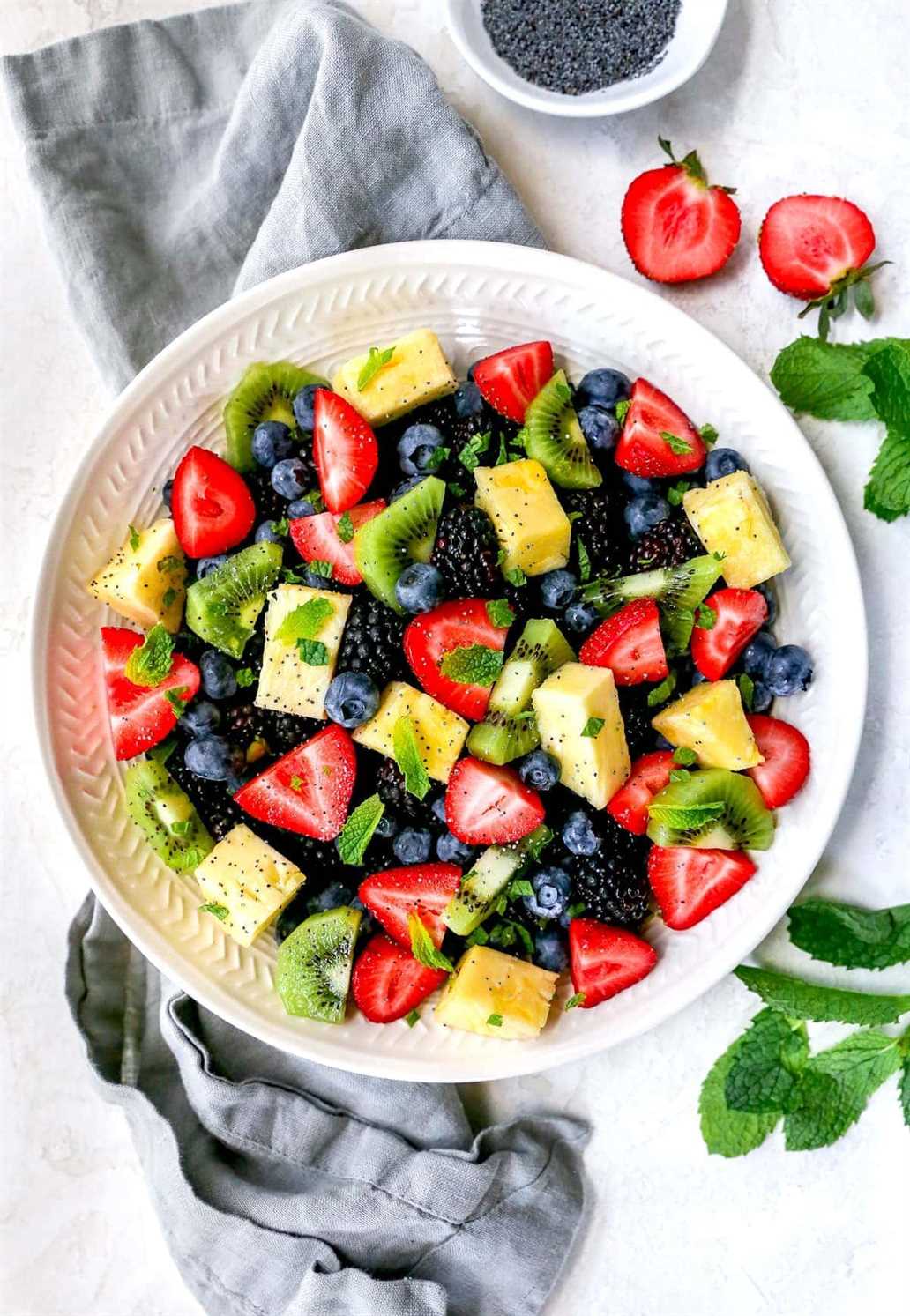 Fruit salad in bowl with citrus dressing and mint