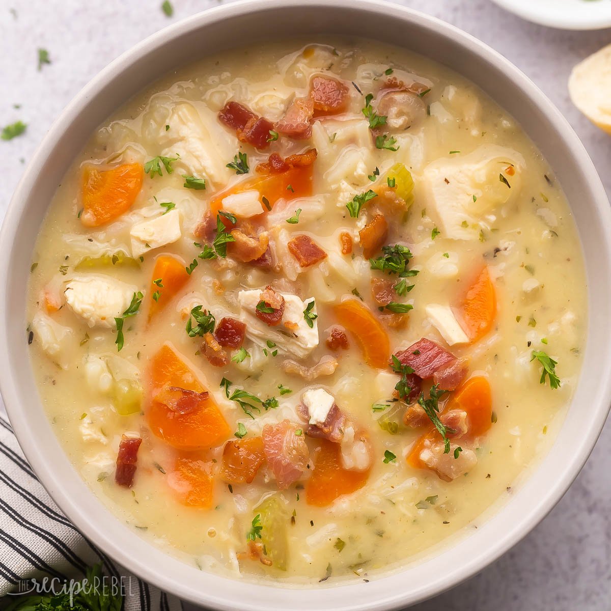 square image of a bowl of chicken rice soup with bacon.