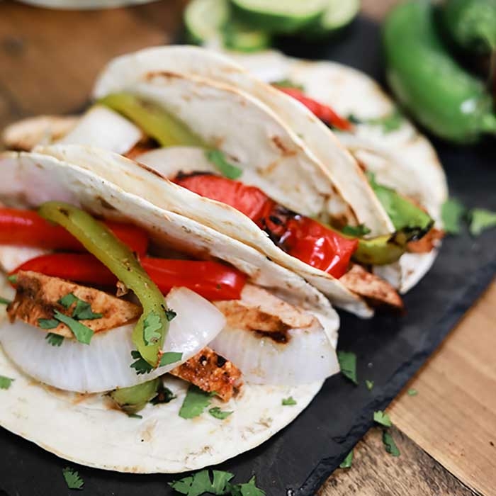 tacos de fajita de pollo a la parrilla sobre tortillas de harina